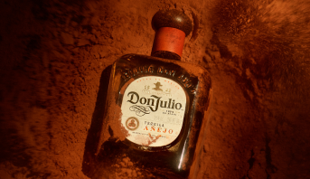 Garrafa de Don Julio Añejo contra fundo vermelho 