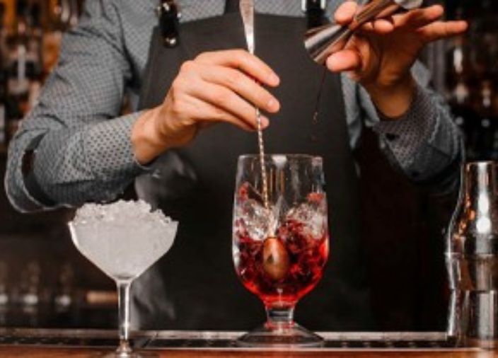 Imagem de um bartender mexendo um drink 
