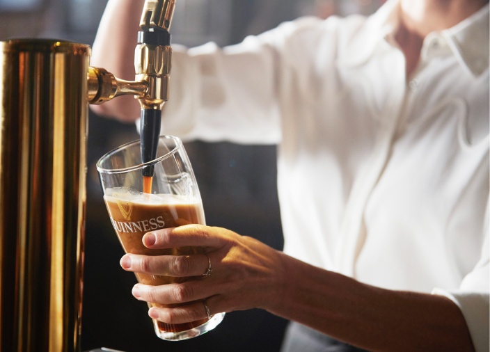 Bartender Pouring A Pint of Guinness into a Guinness Glass 