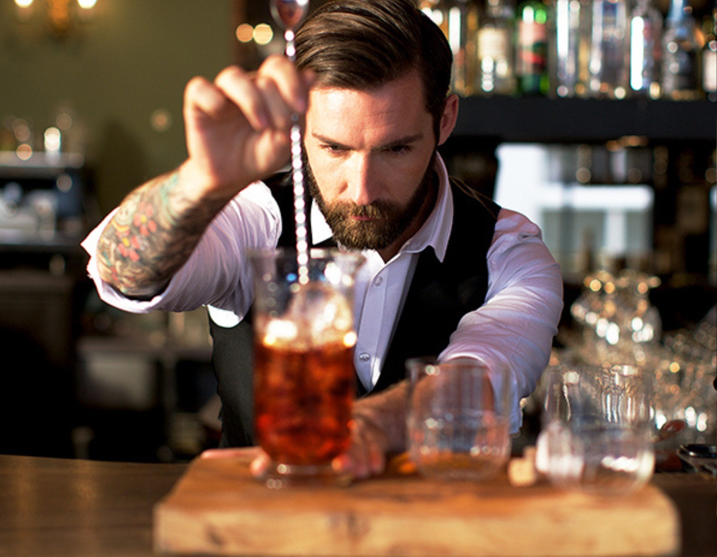 Bartender stirs a cocktail at the bar counter