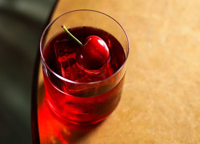 A negroni cocktail with a cherry garnish.