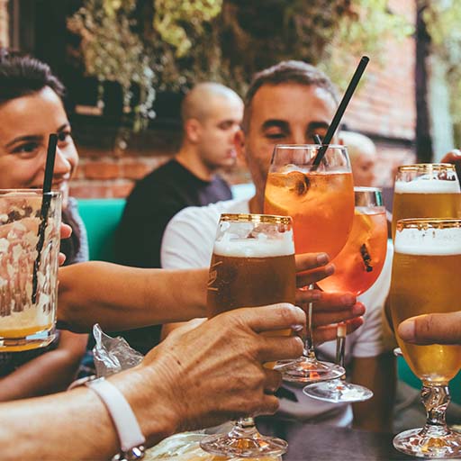 Grupo de convidados aplaudindo com seus copos em um bar 