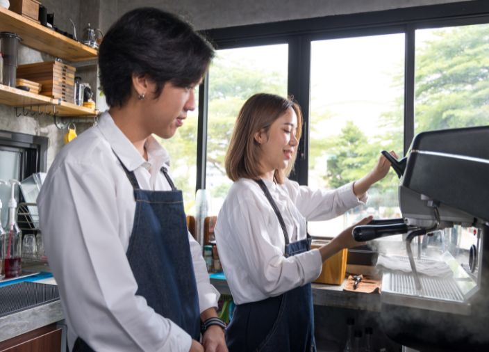 Team members inspecting coffee machine