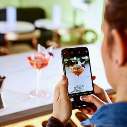 Bartender tomando una foto de un servicio en su teléfono