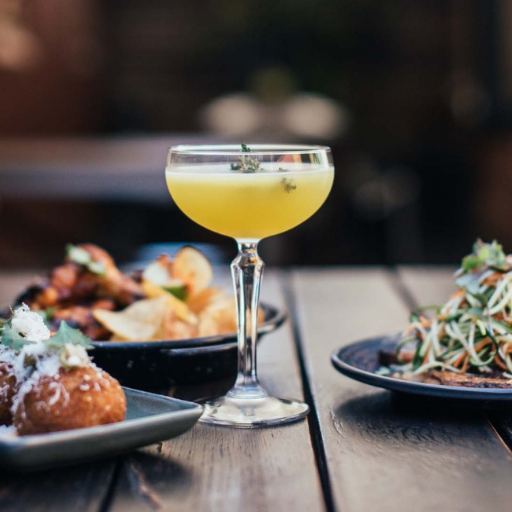 Cocktail surrounded by plates of food