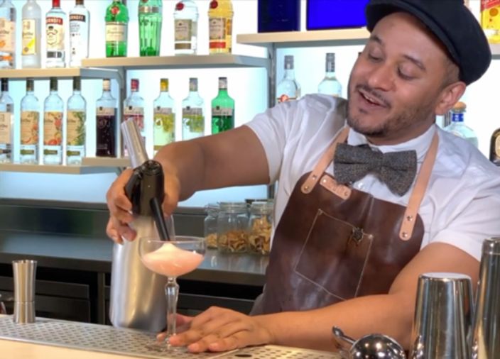 Bartender gaseificando uma bebida no ambiente de um bar 