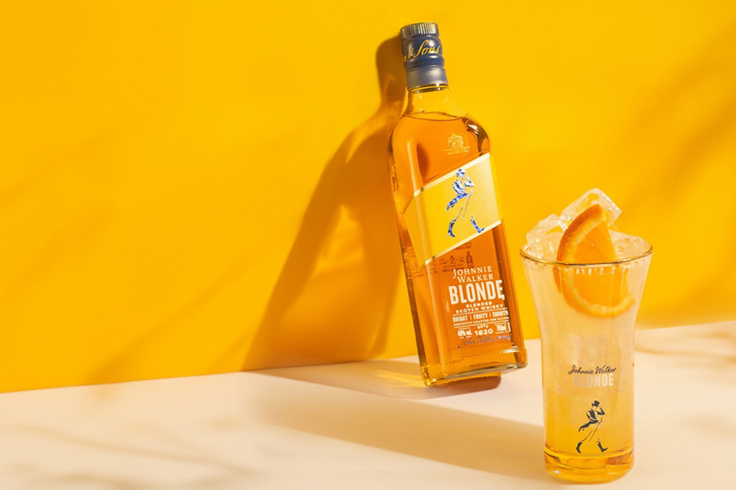 Botella de Johnnie Walker Blonde con bebida en highball