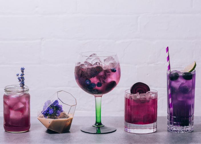 Collection of 5 different cocktails featuring purple in liquid or garnish