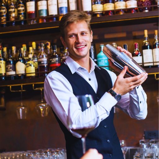 Barman servindo cliente em um bar segurando uma coqueteleira.