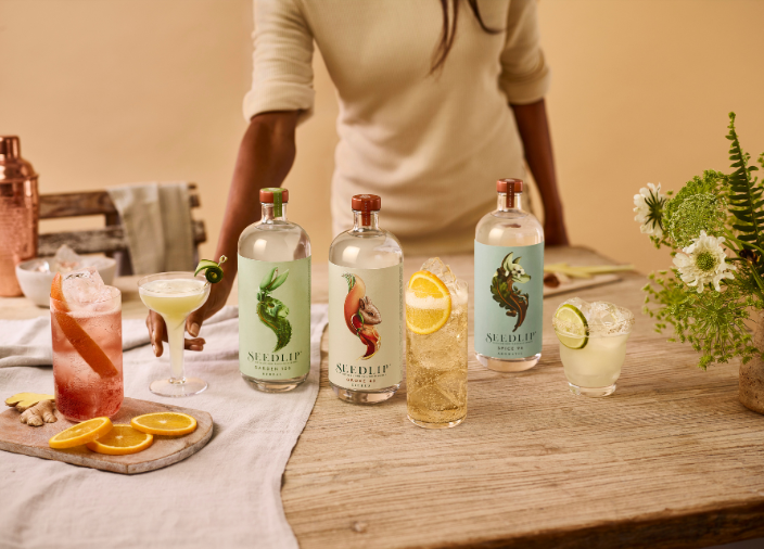 Selección de botellas de Seedlip sobre la mesa rodeadas de cócteles variados