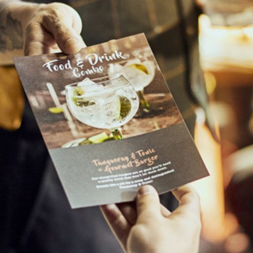 Food and Drinks Menu being presented to a customer in a bar setting