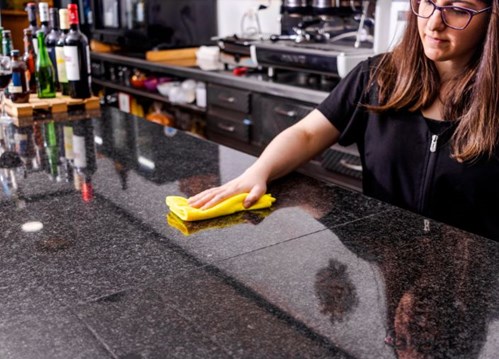 Bartender limpando a superfície do bar com um pano