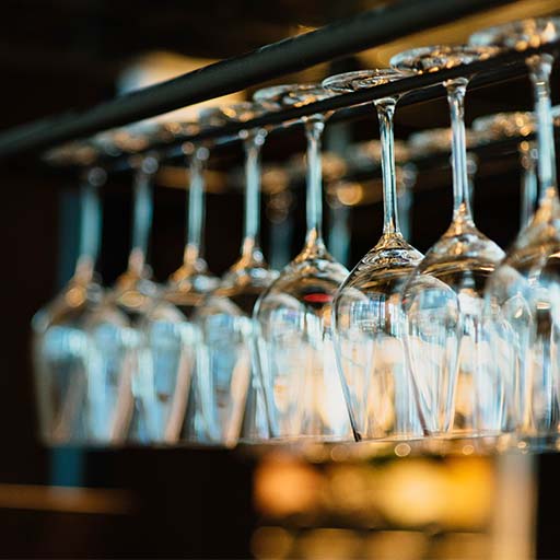 Copas perfectamente organizadas en un estante detrás de la barra