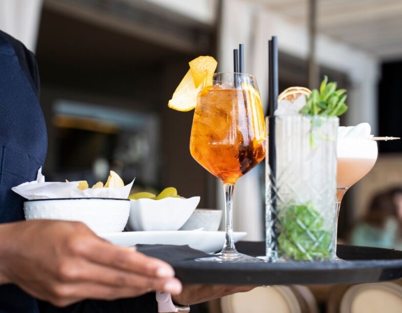 Tablett mit Getränken wird vom Barkeeper getragen