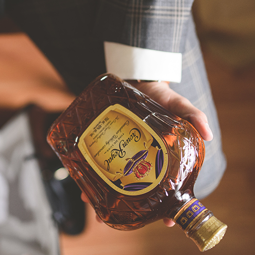 Hand holding a bottle of crown royale whisky