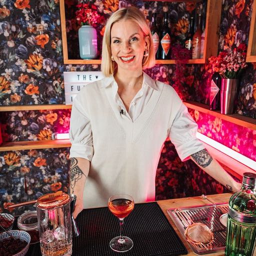 Dominique Maria Krauß steht an einer rosa Bar
