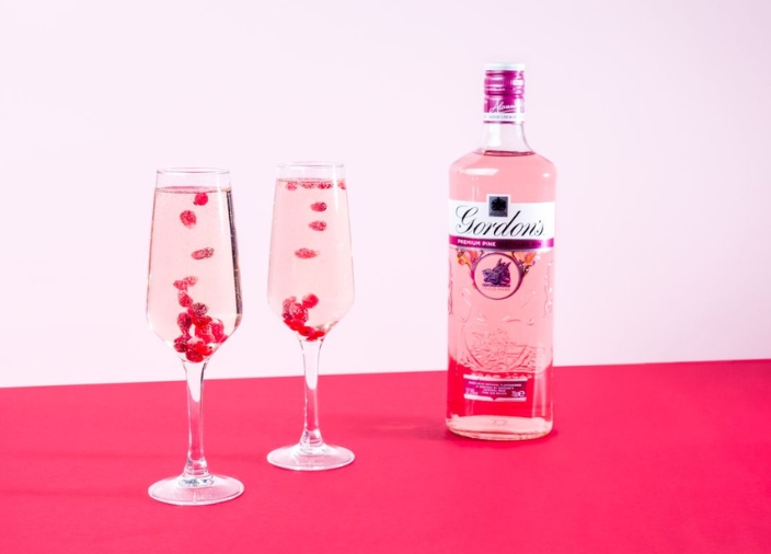 Gordon's Pink bottle next to two cocktails