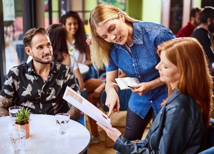 Waitress helping woman choose her order