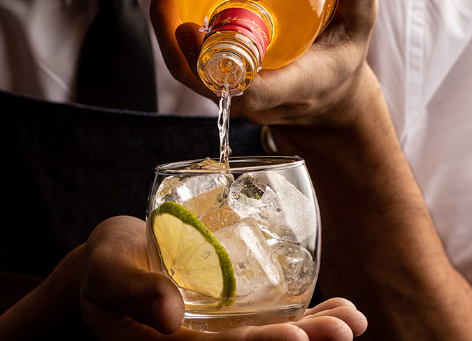 Bartender pouring gin into glass 