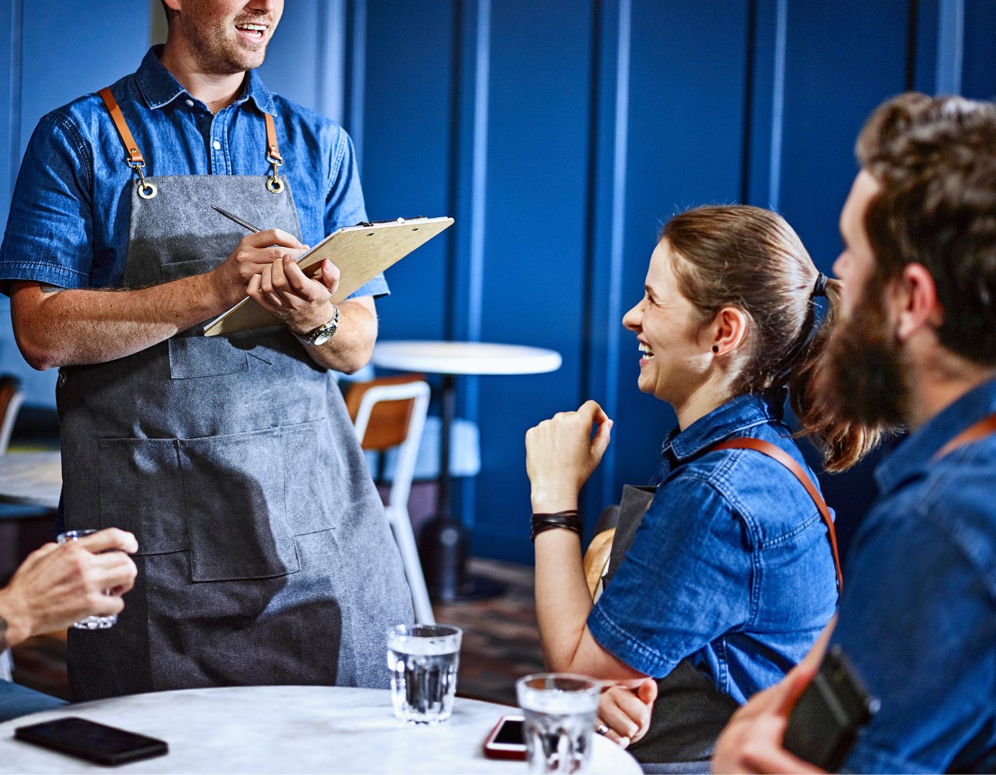 Manager in the bar setting giving a briefing to the employees