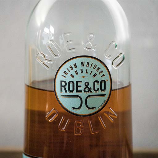 Uma foto de perto de uma garrafa de Whiskey irlandês da Roe & Co