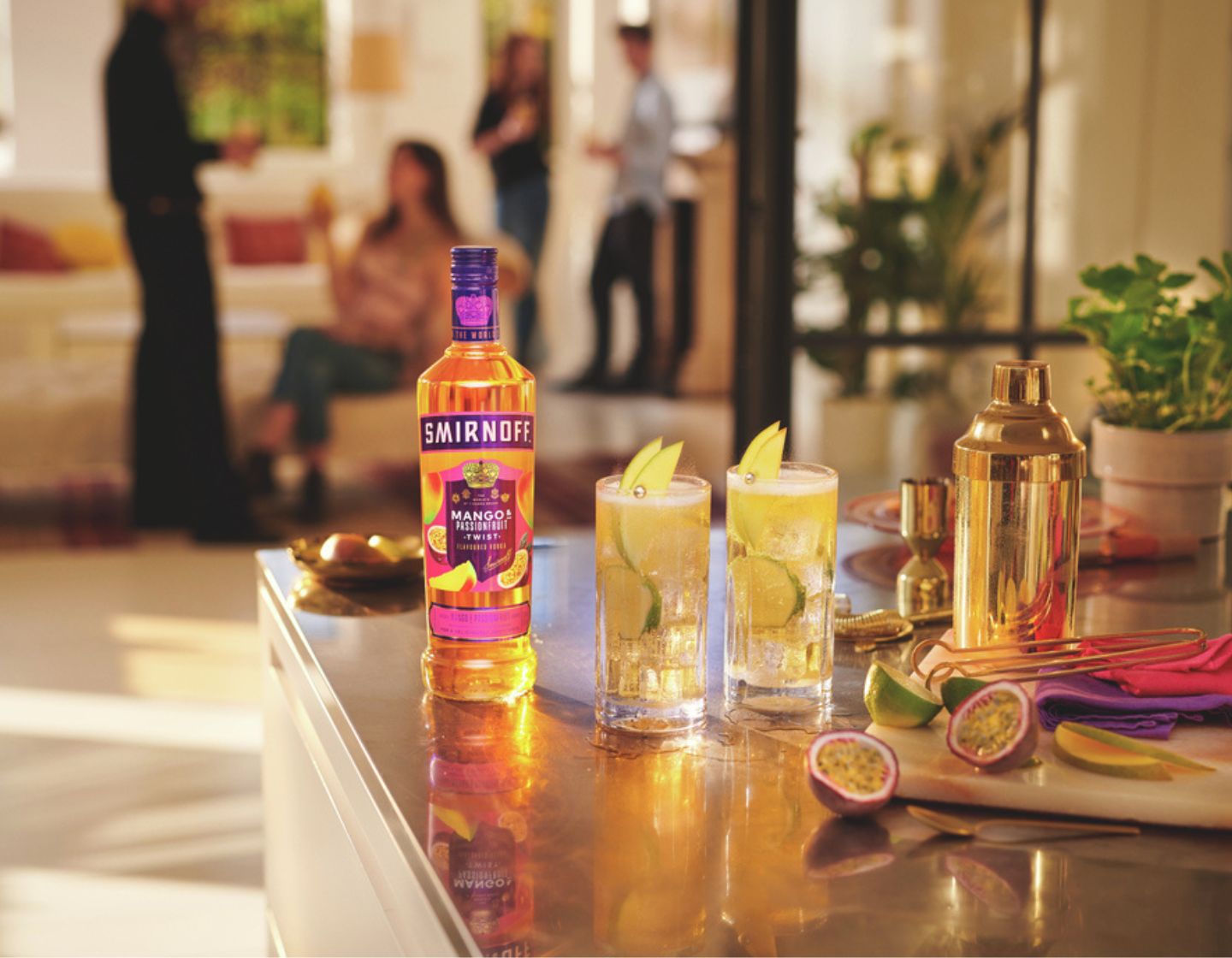 Smirnoff Tamarind bottle on a living room table, beside two summer cocktails.