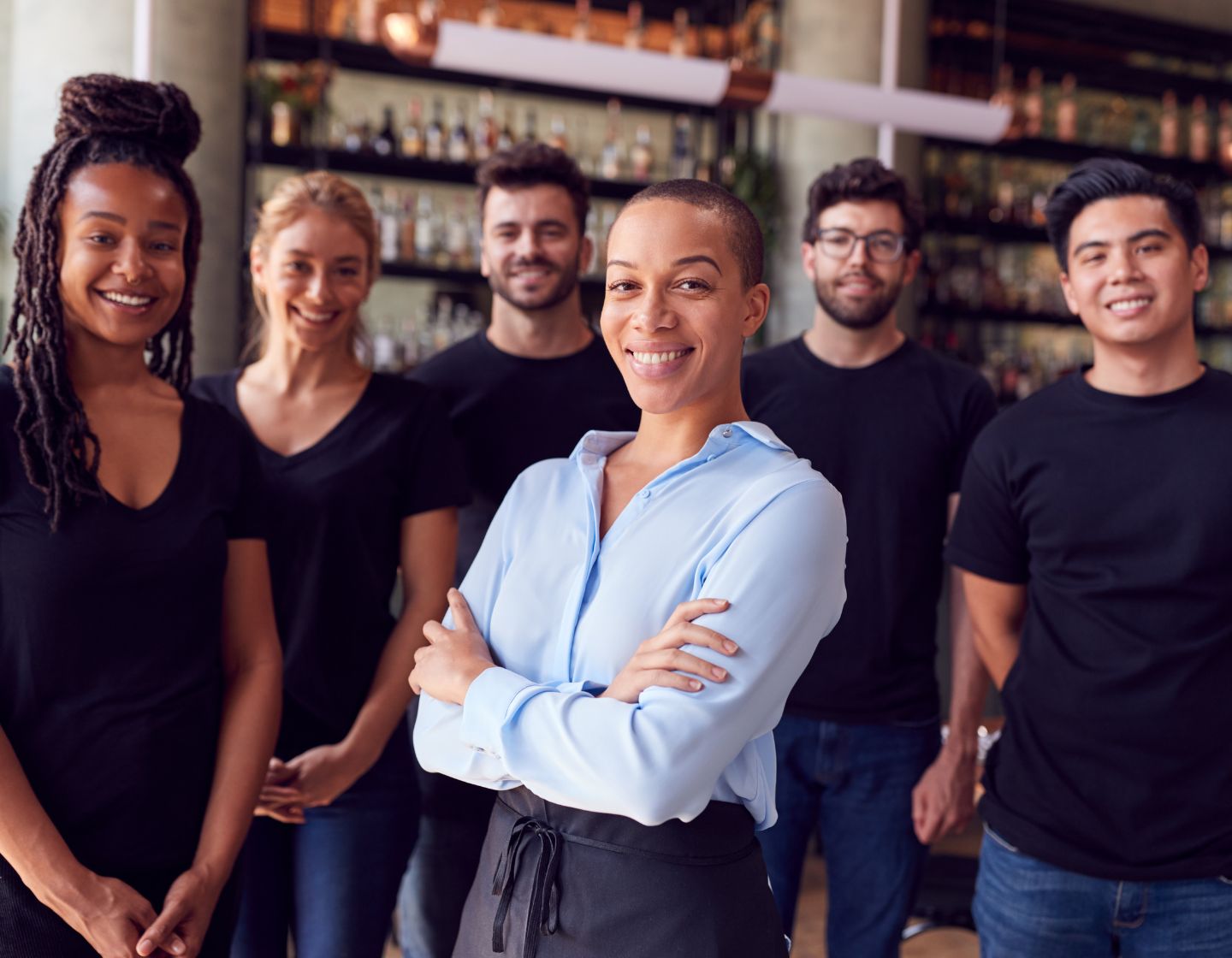 Woman standing in a leadership role with two male employees beside her