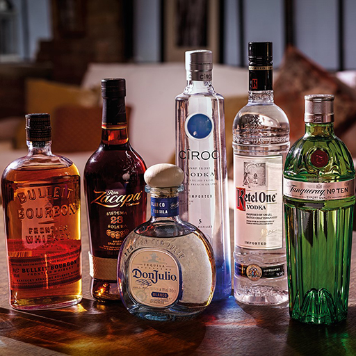 un grupo de botellas de alcohol, de izquierda a derecha, Johnnie Walker Gold Label Reserve, Bulleit Bourbon, Zacapa, Don Julio, Cîroc, Ketel One, Tanqueray No Ten y Johnnie Walker Blue Label.
