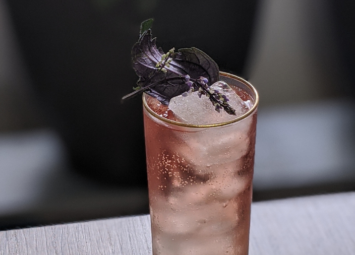 Whiskey cocktail garnished with sprig of lavender