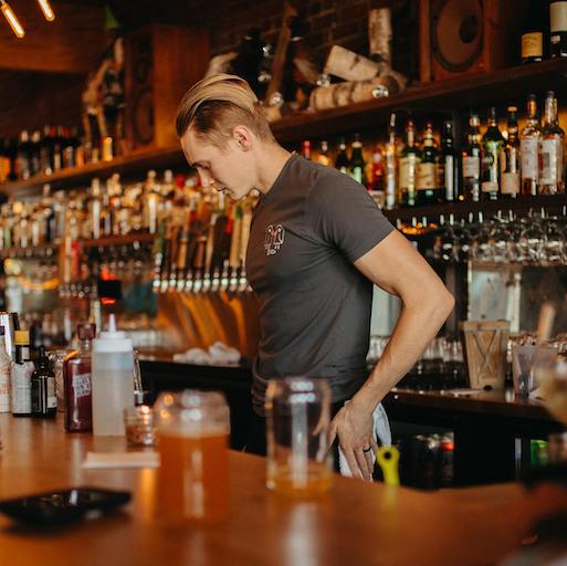 Ein Barkeeper steht hinter dem Tresen