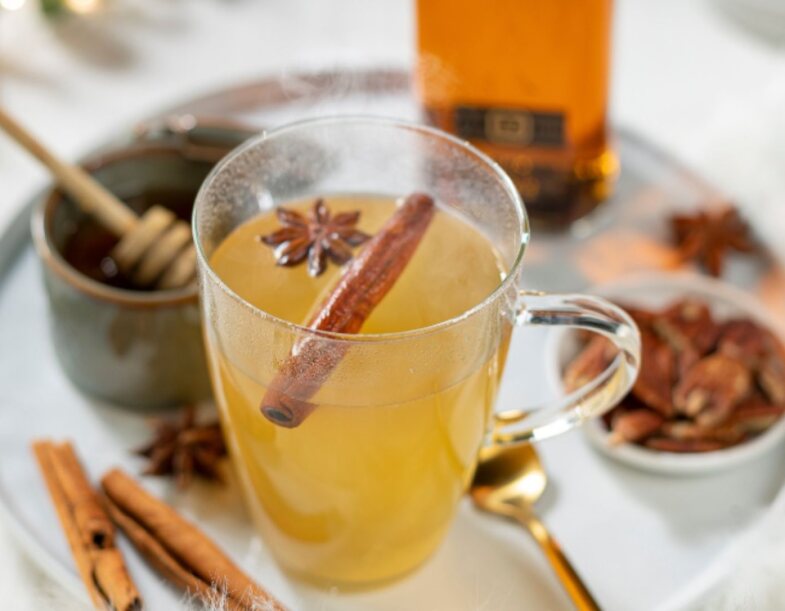 Whisky Sour neben einer Flasche Johnnie Walker Black Label und Zitronen.