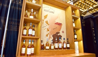 Map of Scotland on wall with single malt whisky bottles on shelves