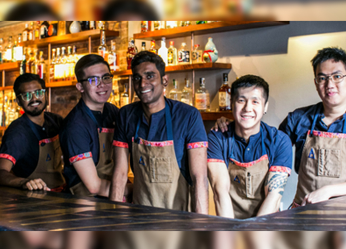 Membros da equipe da DBA juntos, um em pé, segurando uma prancheta e fazendo anotações. 