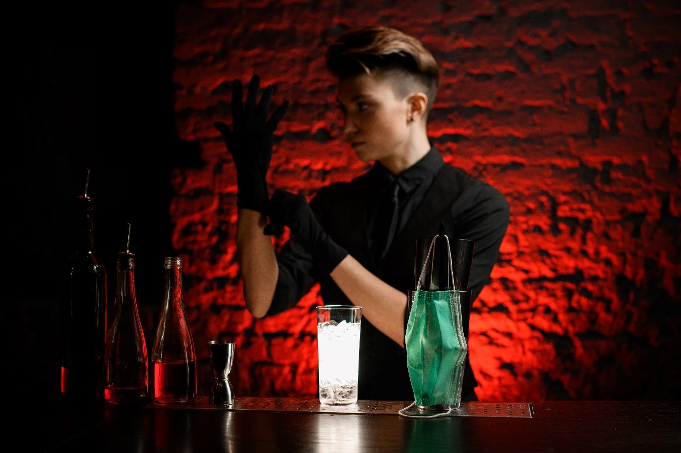 Imagem de um bartender cortando limões usando luvas 