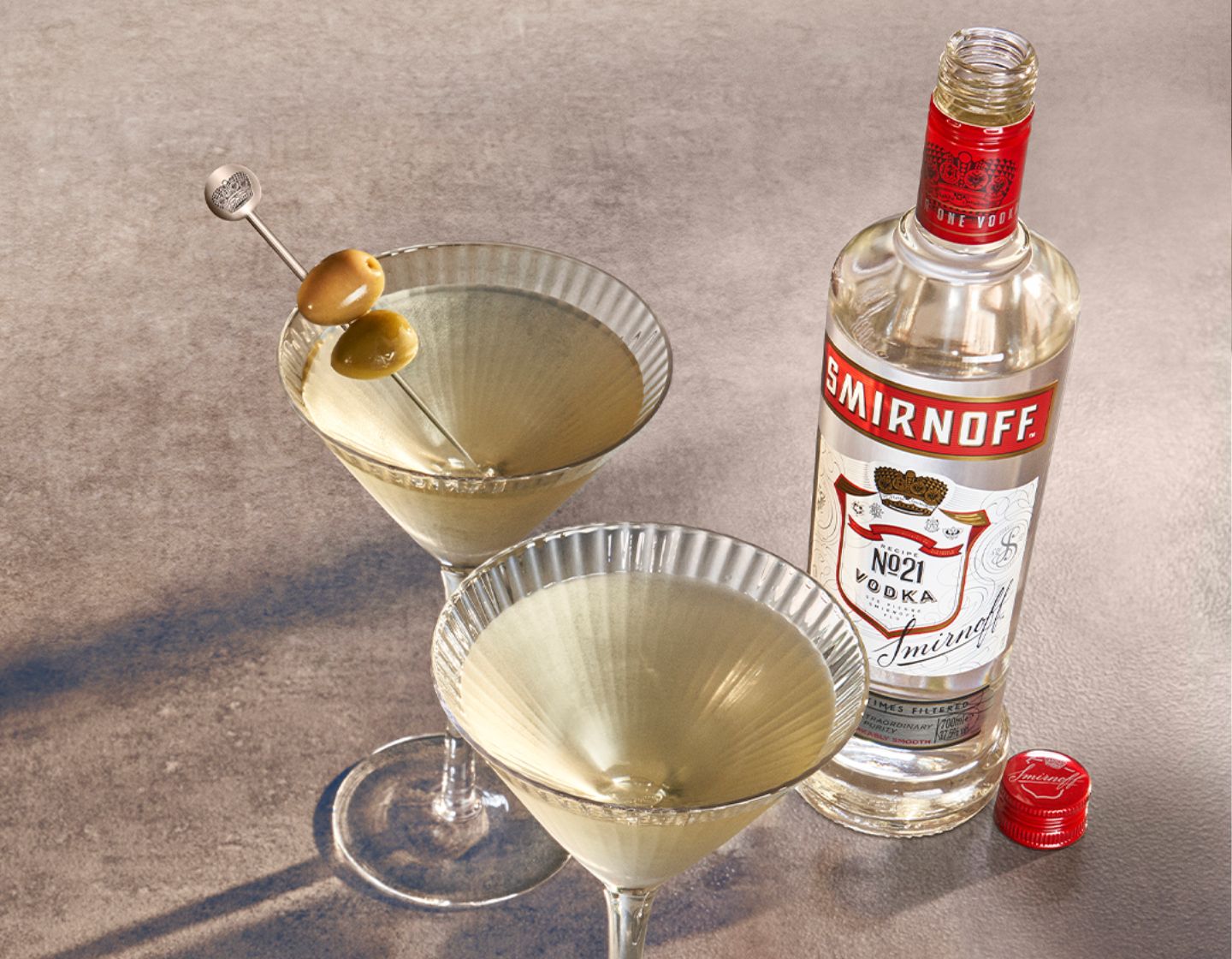 Garrafa de Vodka Smirnoff ao lado de duas doses de vodka em copos de latão