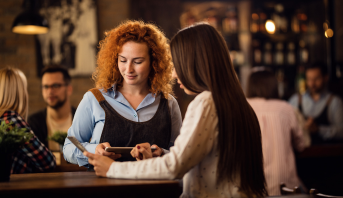 Bartender servindo coquetel a um cliente no bar 