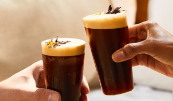 Two hands holding two vodka coffee cocktails