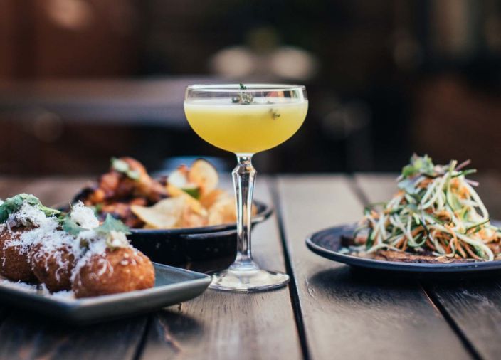 cocktail on table with range of food