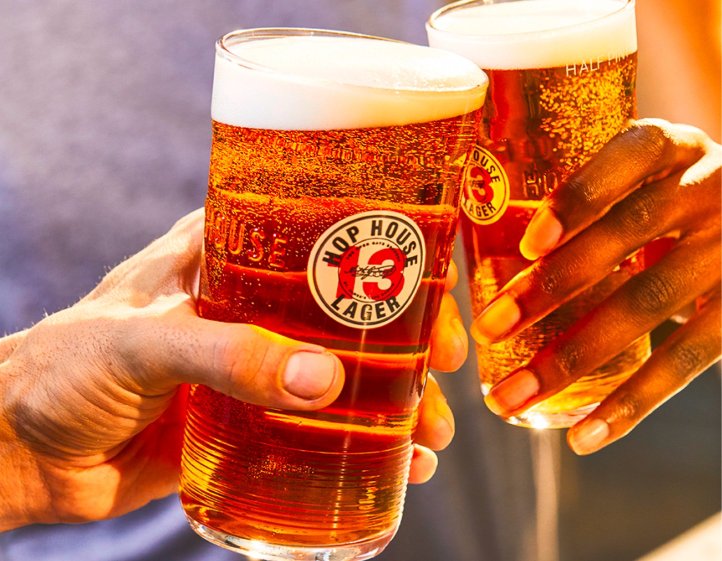 Dos manos brindando con pintas de Hop House 13 Lager