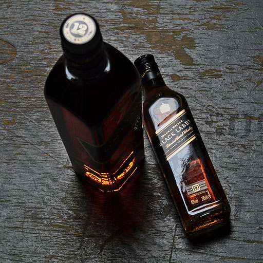 Two bottles of Johnnie Walker Black Label. One standing up and one laying down.