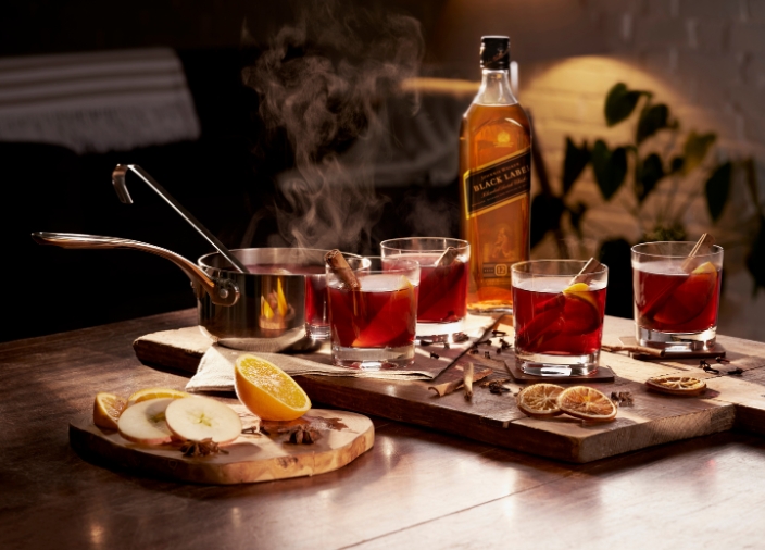 Botella de Johnnie Walker Black con cocteles y comida