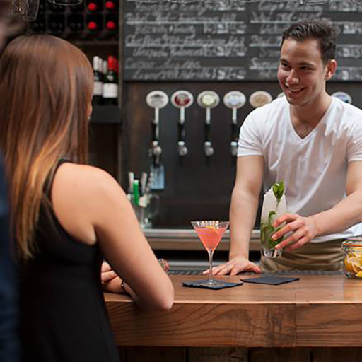 Bartender passing a cocktail to a customer