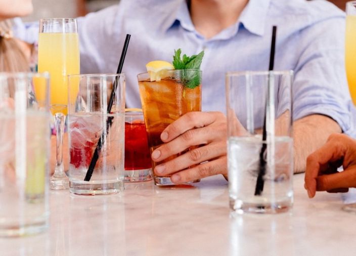 Customers sitting at a table with a selection of drinks 