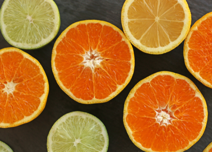 Metades de frutas cítricas variadas sobre fundo escuro