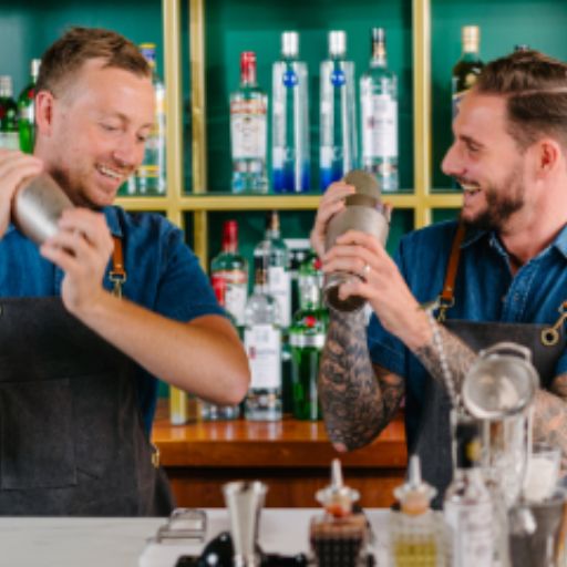 bartenders behind bar shaking cocktails