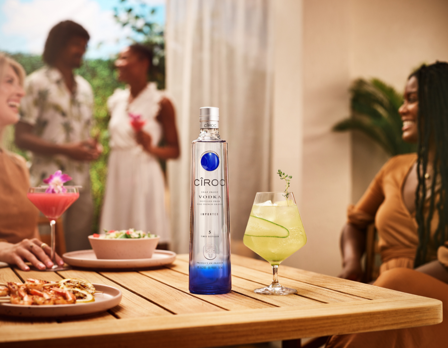 Bottle of vodka beside cocktail