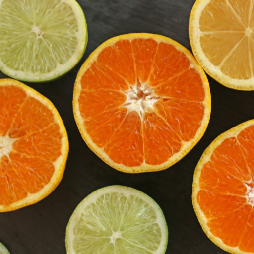 Metades de frutas cítricas variadas sobre fundo escuro