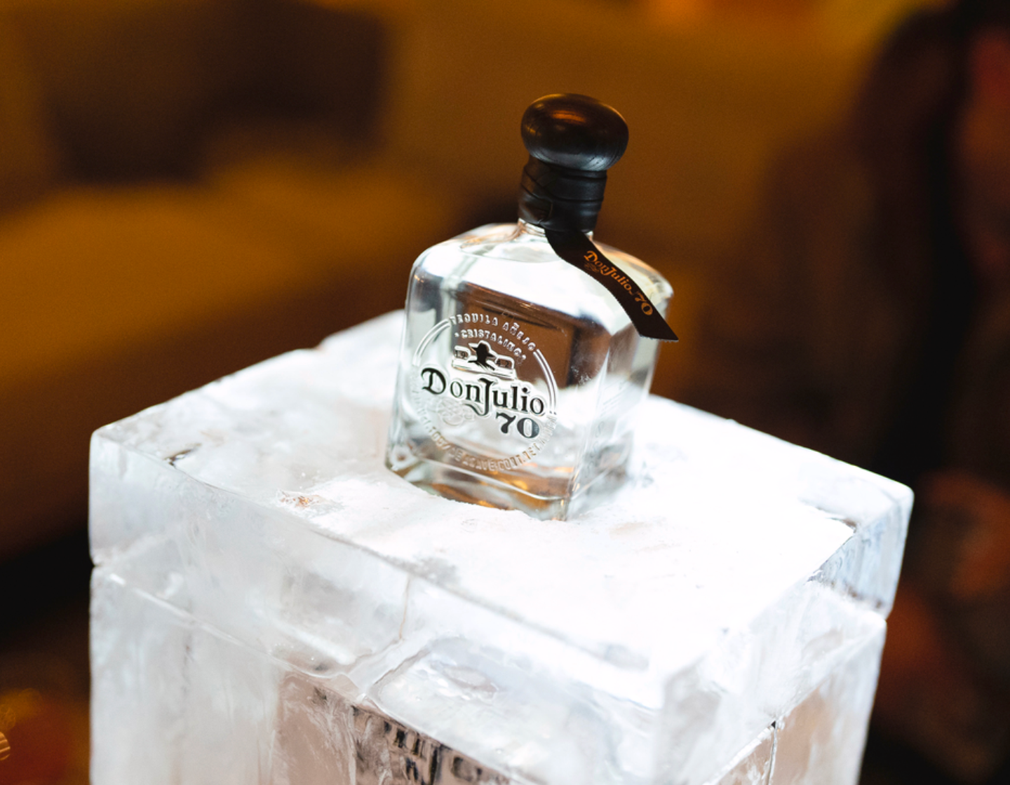 Garrafa de tequila Don Julio 70 retratada em pé sobre um bloco de gelo.