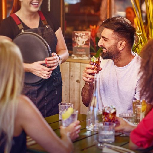Customers serves drinks at a table.