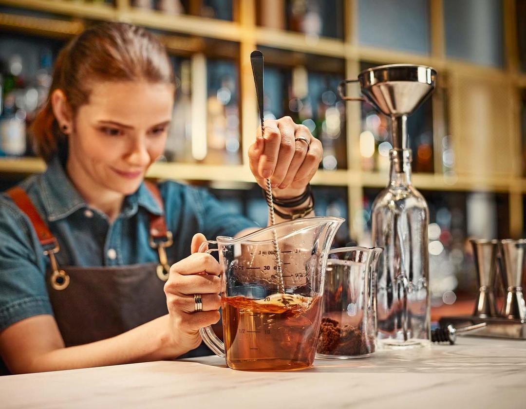 Bartender centrándose en medir la bebida